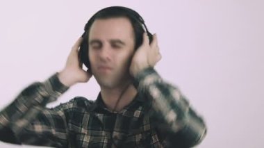 Genç adam kulaklıkla müzik dinliyor.