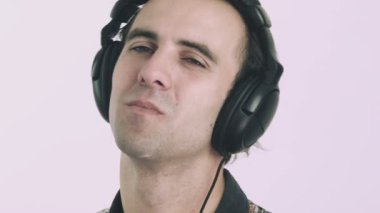 Genç adam kulaklıkla müzik dinliyor.