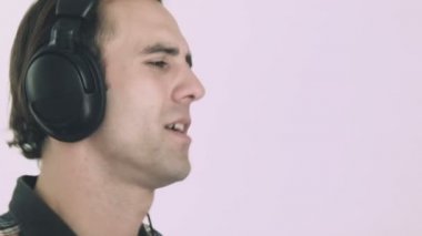 Genç adam kulaklıkla müzik dinliyor.