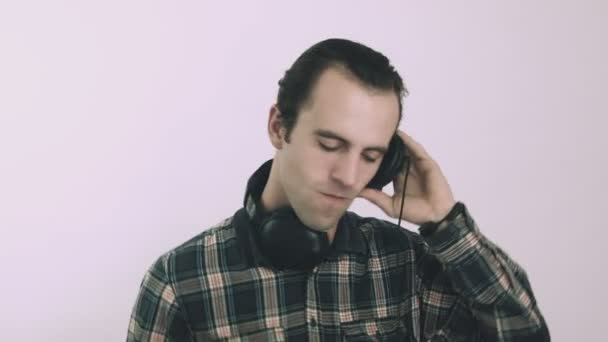 Jonge mannelijke Dj luisteren naar muziek op hoofdtelefoon — Stockvideo