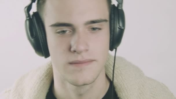 Jonge man luisteren naar muziek op de hoofdtelefoon — Stockvideo