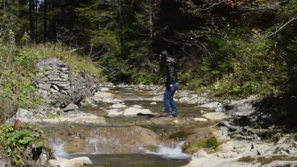 Fata curajoasă traversând un râu într-o pădure — Videoclip de stoc