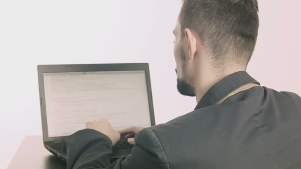 Geschäftsmann Computerprogrammierer tippt an seinem Schreibtisch und blickt in die Kamera — Stockvideo