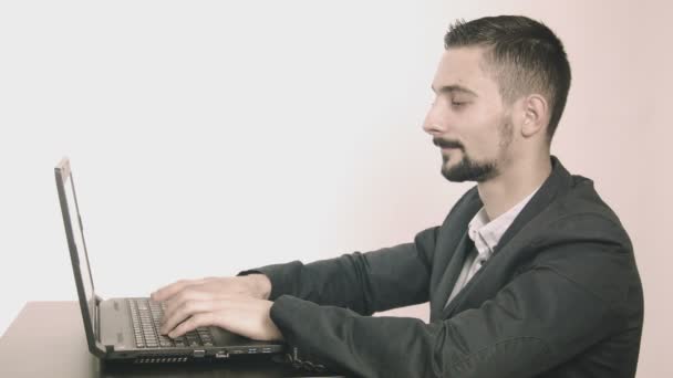 Business man computer programmer typing at his desk and looking at camera — Stock Video