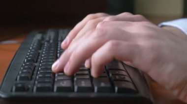 Genç bir adam close-up tipik bir dizüstü bilgisayar klavye üzerinde eller