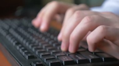 Genç bir adam close-up tipik bir dizüstü bilgisayar klavye üzerinde eller