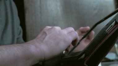 Bir tablet PC'de çalışma ve bir kafede kahve içme işadamı