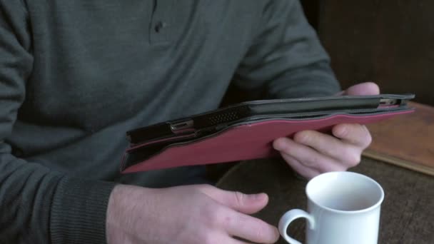 Zakenman werken op een tablet pc en drinken koffie in een koffieshop — Stockvideo