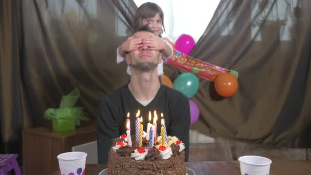 Fiatal jóképű férfi fúj gyertyák a születésnapi torta az ő lánya, a meglepetés party — Stock videók