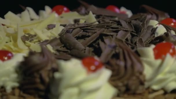 Detalhe de um delicioso bolo de chocolate girando em um fundo preto — Vídeo de Stock