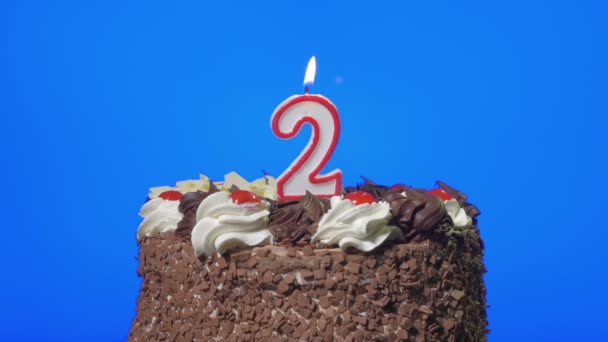 Soplando la vela número dos de cumpleaños en un delicioso pastel de chocolate, pantalla azul — Vídeos de Stock