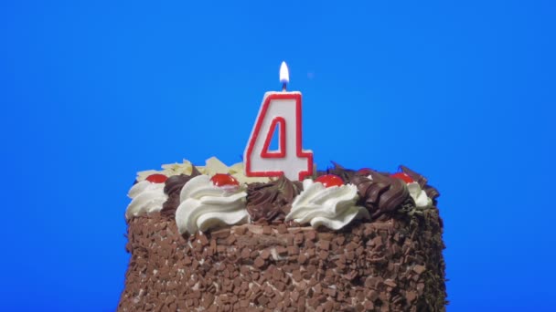 Soplando la vela de cumpleaños número cuatro en un delicioso pastel de chocolate, pantalla azul — Vídeo de stock