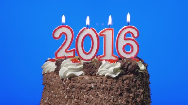 4k - Blowing out new year 2016 candles on a delicious chocolate cake, blue screen Stock Video