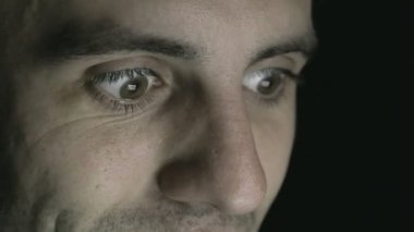 Genç adam bir tablet veya dizüstü bilgisayar - gözleri ifadeler bakıyor