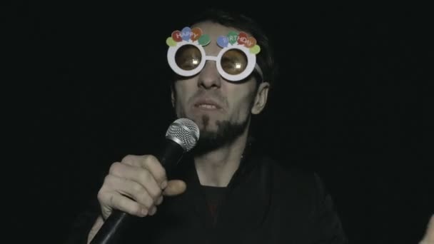Joven deejay masculino con gafas locas y micrófono — Vídeos de Stock