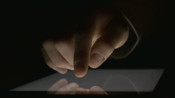 Close-up van hand gebruiken, tablet pc in het donker — Stockvideo