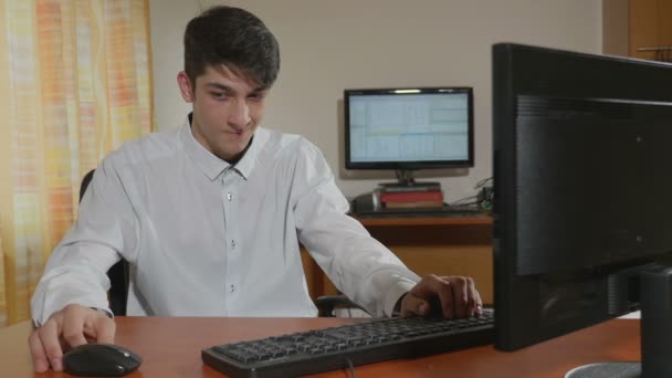 Schöner junger Programmierer gelangweilt beim Spielen bei der Arbeit — Stockvideo