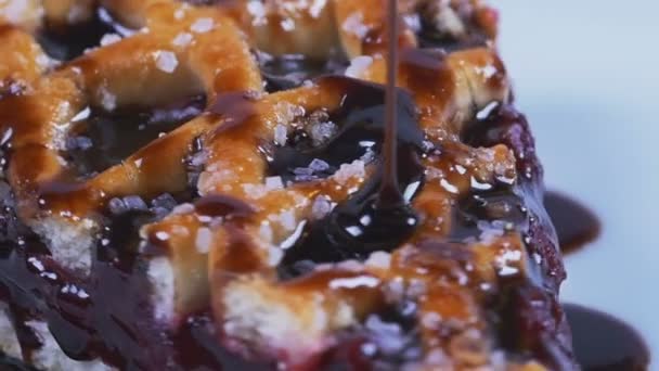 Вкусный расплавленный шоколадный сироп, льющийся на вишневый пирог в замедленной съемке — стоковое видео