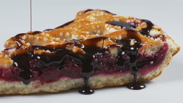 Вкусный расплавленный шоколадный сироп, льющийся на вишневый пирог в замедленной съемке — стоковое видео