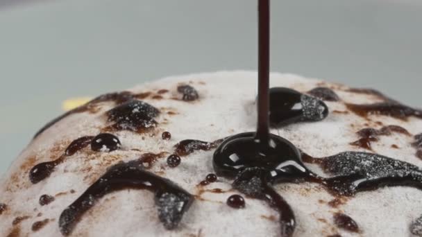 Délicieux sirop de chocolat fondu versant sur un beignet au ralenti — Video