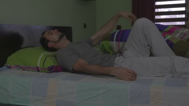 Jovem homem bonito na cama tentando dormir — Vídeo de Stock