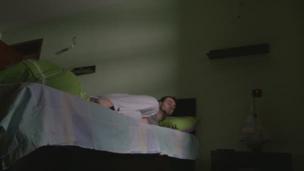 Jonge knappe man om uit bed in de ochtend — Stockvideo