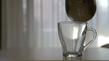 Gecenin ağır çekimde şeffaf bir kupa sıcak kahve dökme