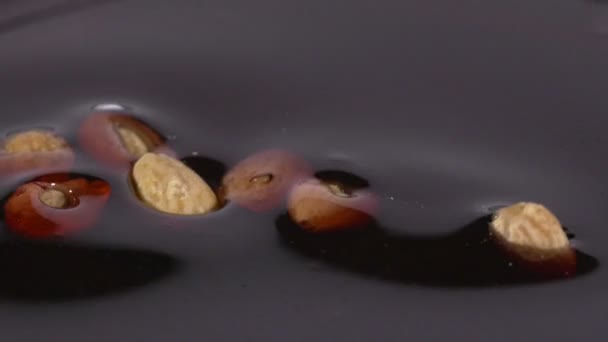 Primer plano de deliciosas almendras asadas que caen en el jarabe de chocolate — Vídeos de Stock