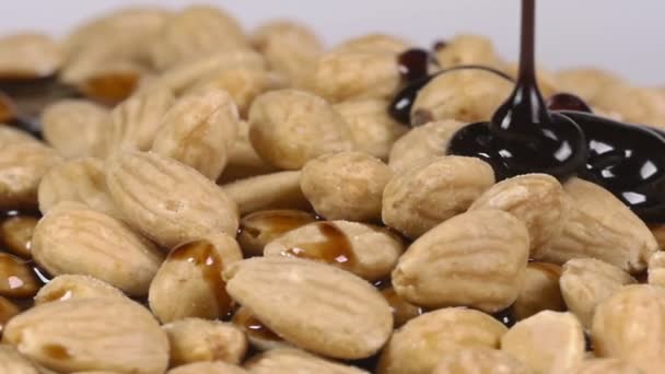 Pouring delicious chocolate syrup over almonds — Stock Video