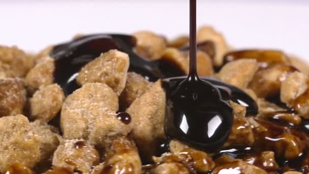 Pouring delicious chocolate syrup over mixed nuts — Stock Video