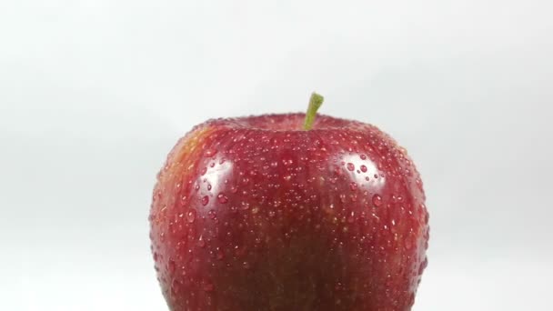 Primer plano de una deliciosa manzana roja rociada con agua giratoria — Vídeos de Stock