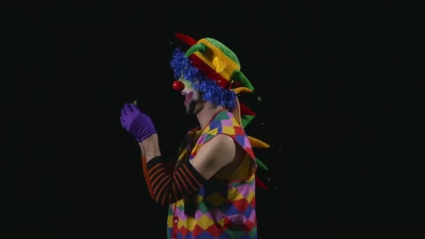 Unga rolig clown blåsa upp en ballong och balansera den på näsan — Stockvideo