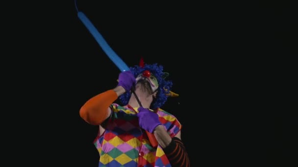 Молодой забавный клоун делает пуделя из воздушного шара — стоковое видео