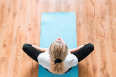 Tahta zeminde yoga yapan genç ve güzel bir jimnastik salonunun manzarası.