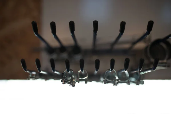 A large number of metal pipe clamps arranged by size, selective focus
