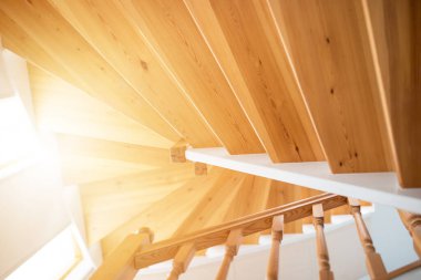 Güneşli bir günde beyaz, modern bir evde ahşap bir merdiven.