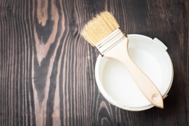 Banka boya ve fırça ahşap arka plan üzerinde