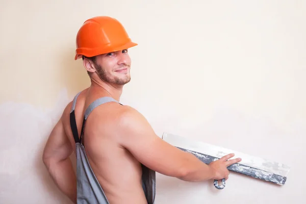 Man in overalls with a large spatula — Stock Photo, Image