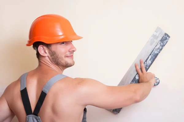 Man in overalls with a large spatula — Stock Photo, Image