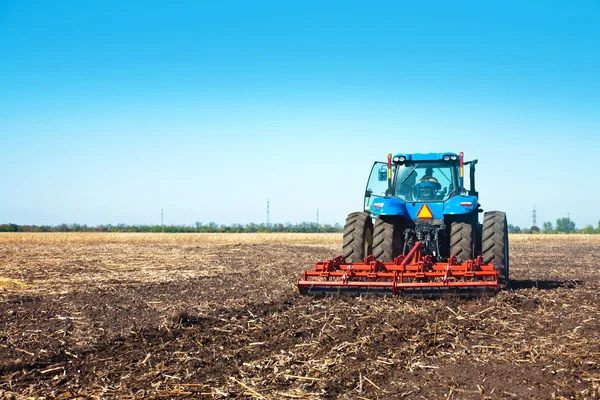 Blå traktor i feltet – stockfoto