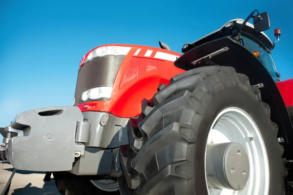 Red tractor against the clear blue sky — Stock Photo, Image