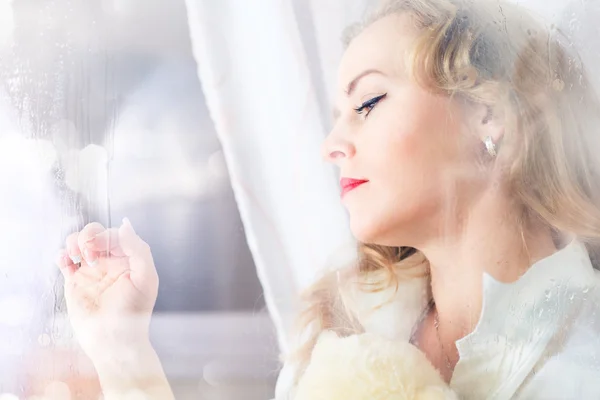 Close-up portrait of a sad beautiful woman near the window — Stock Photo, Image