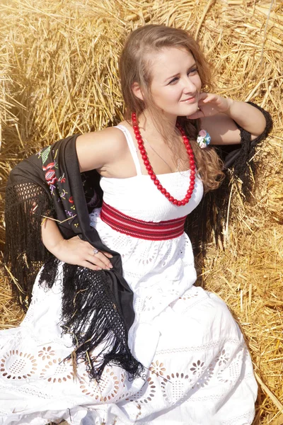 Vacker ung kvinna i en vit sundress nära höstack — Stockfoto