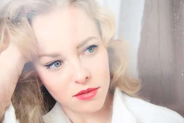 Close-up portrait of a sad beautiful woman near the window — Stock Photo, Image