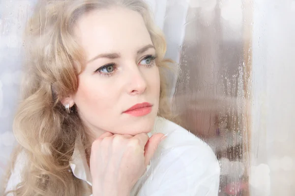 Close-up portrait of a sad beautiful woman near the window — Stock Photo, Image