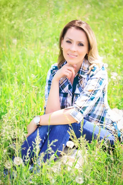 Portret van een mooi aantrekkelijke vrouw in het gras — Stockfoto