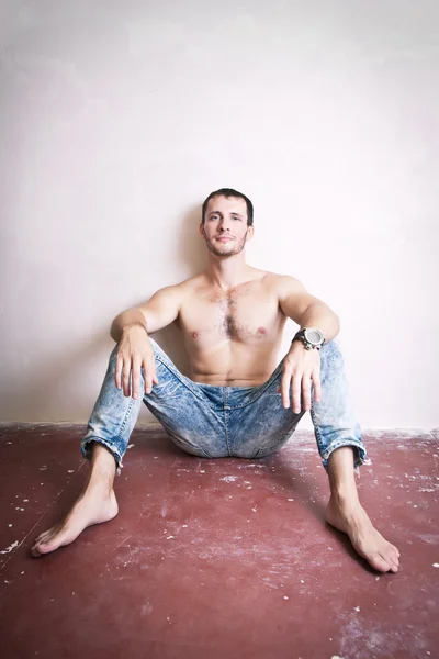 Doordachte aantrekkelijke man zittend op de vloer — Stockfoto