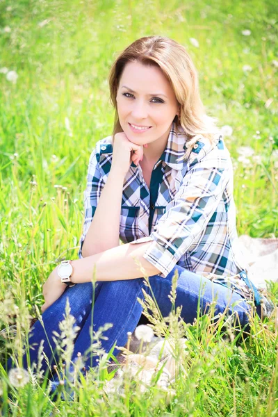 Portret van een mooi aantrekkelijke vrouw in het gras — Stockfoto