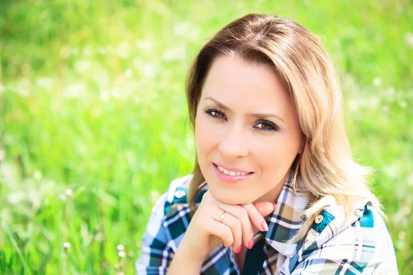 Portrait of a beautiful attractive woman in the grass — Stock Photo, Image