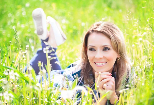 Portret piękna, młoda kobieta, leżąc na trawie — Zdjęcie stockowe